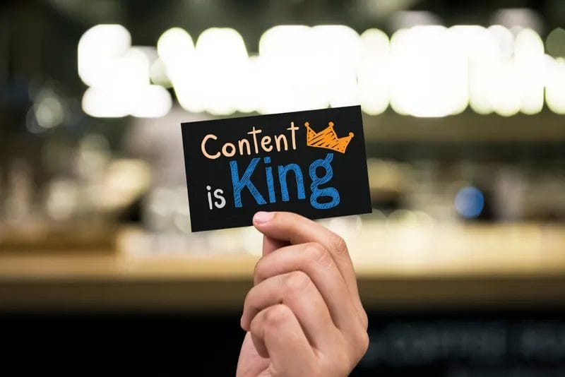 Hand holding card with 'Content is King' message.