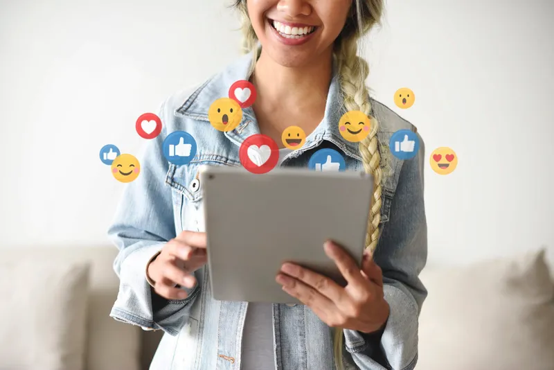 Person using tablet with social media icons.