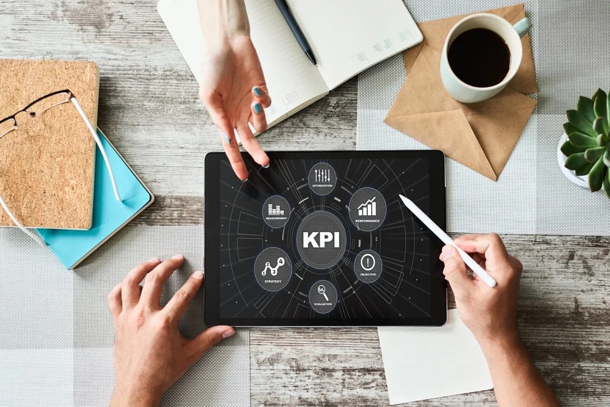 Tablet displaying KPI dashboard on wooden desk.