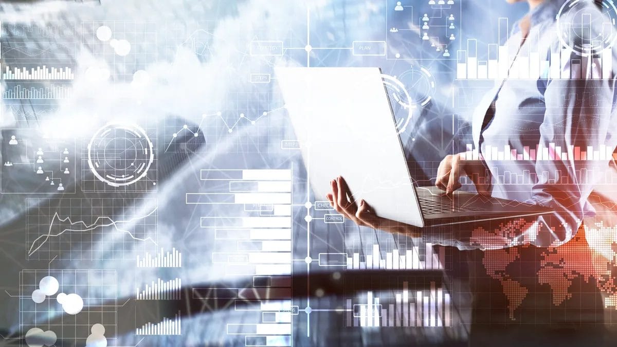 Person using laptop with digital data overlay.
