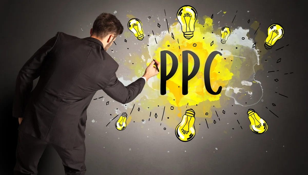 Person writing PPC with lightbulbs on wall