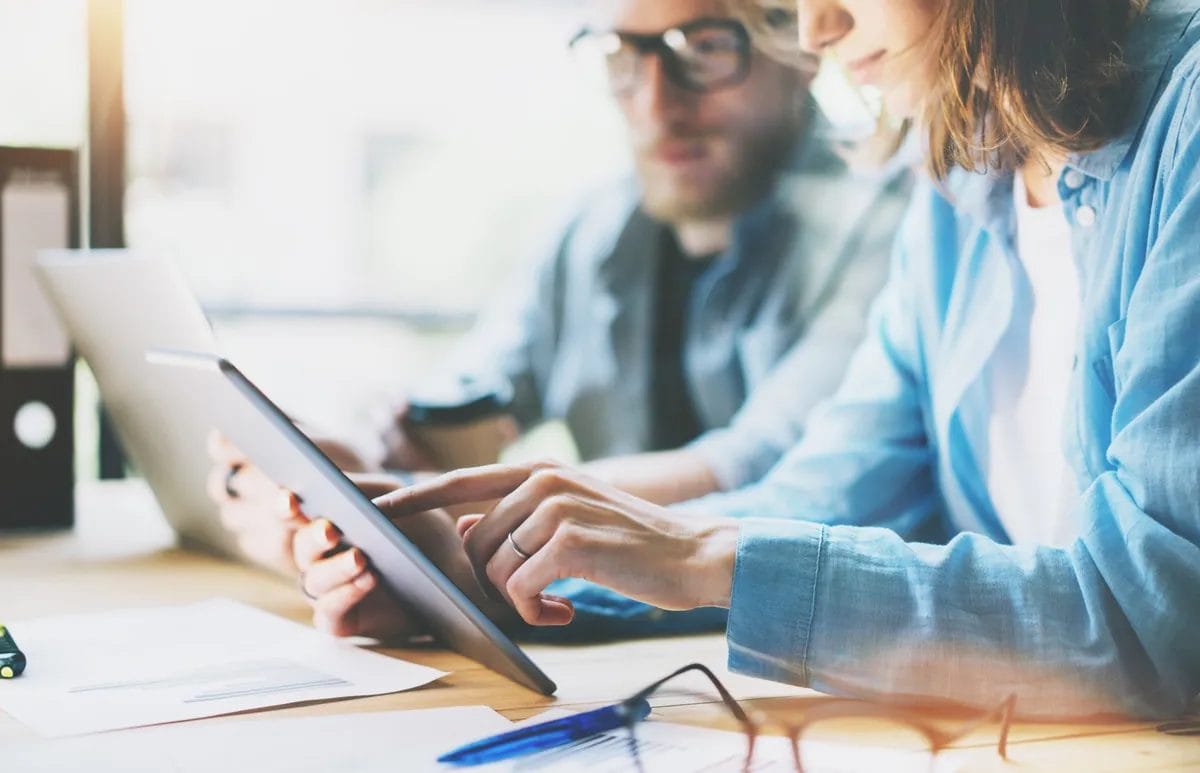 People working with digital devices in office.