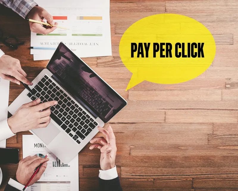 Team planning pay-per-click strategy on laptop